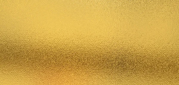 Gold wall texture background. Yellow shiny gold paint on wall serface with light reflection, vibrant golden luxury wallpaper shee