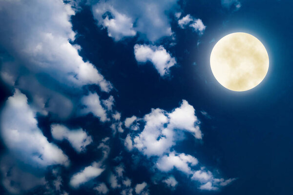 Full moon on night blue sky with white cloud background. Outdoor nature midnight tranquil scene with super full moon glowing bright light shine on cloudy sk