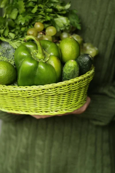 green vegetables and fruits in a wicker basket
