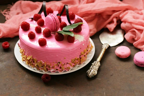 amazing pink cake with raspberries on an iron table
