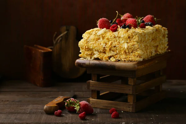 ナポレオン積層木製テーブルの上の果実とケーキ — ストック写真