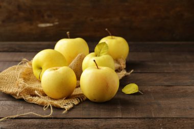 ahşap bir masa üzerinde sarı olgun organik elma