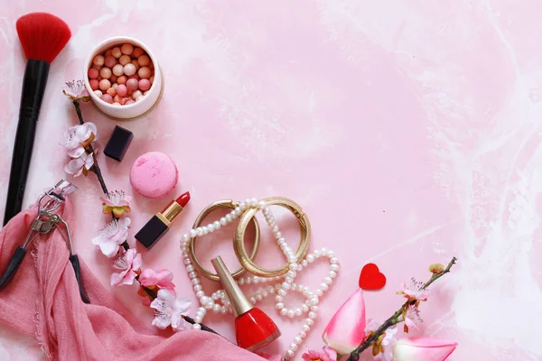 pink background with cosmetics and jewelry for women