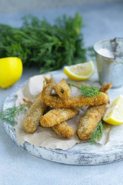 öğle yemeği için kızarmış balık, limon ve otlar ile