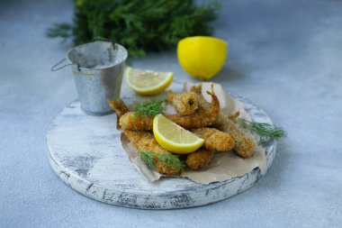 öğle yemeği için kızarmış balık, limon ve otlar ile