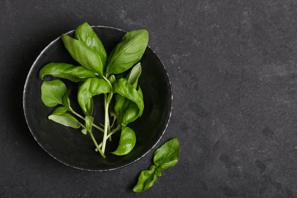 siyah gıda arka plan üzerinde bir tabakta kokulu fesleğen otlar