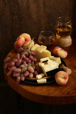 ahşap bir masa üzerinde peynir, üzüm ve şarap, rustik tarzı