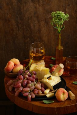 ahşap bir masa üzerinde peynir, üzüm ve şarap, rustik tarzı
