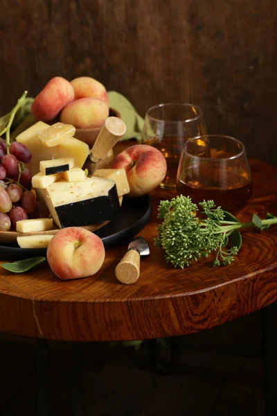 ahşap bir masa üzerinde peynir, üzüm ve şarap, rustik tarzı