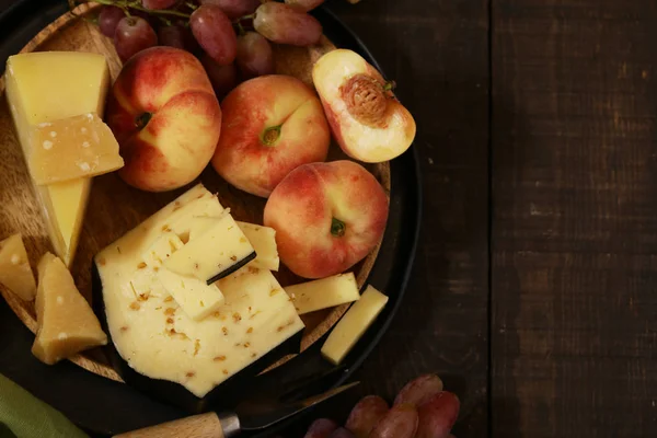 ahşap bir masa üzerinde peynir, üzüm ve şarap, rustik tarzı
