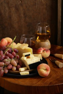 ahşap bir masa üzerinde peynir, üzüm ve şarap, rustik tarzı