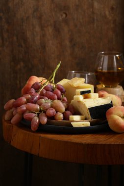 ahşap bir masa üzerinde peynir, üzüm ve şarap, rustik tarzı