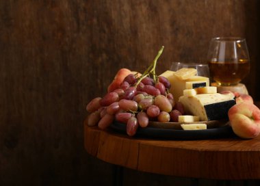 ahşap bir masa üzerinde peynir, üzüm ve şarap, rustik tarzı