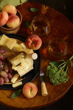 ahşap bir masa üzerinde peynir, üzüm ve şarap, rustik tarzı