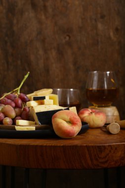 ahşap bir masa üzerinde peynir, üzüm ve şarap, rustik tarzı