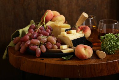ahşap bir masa üzerinde peynir, üzüm ve şarap, rustik tarzı