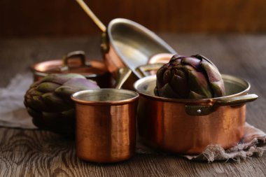 Ahşap arka planda bakır kaplar, tencereler, kepçe ve tava