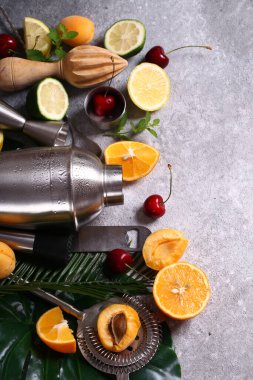 Gri arka planda kokteyl karıştırıcı ve meyveler