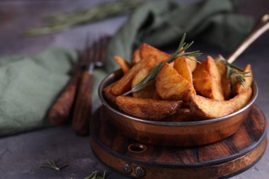 Tavada kızartılmış biberiyeli patates dilimleri.