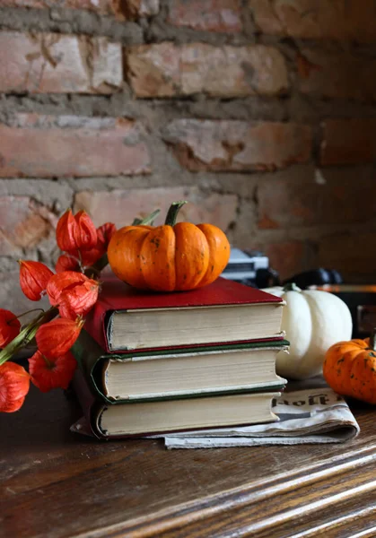 autumn still life with decorative pumpkins and books