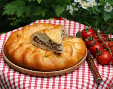Masada öğle yemeği için ev yapımı etli turta.