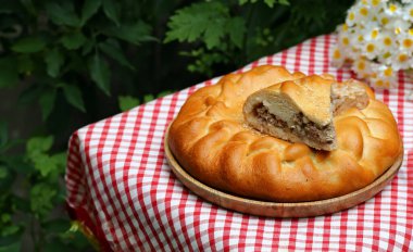 Masada öğle yemeği için ev yapımı etli turta.