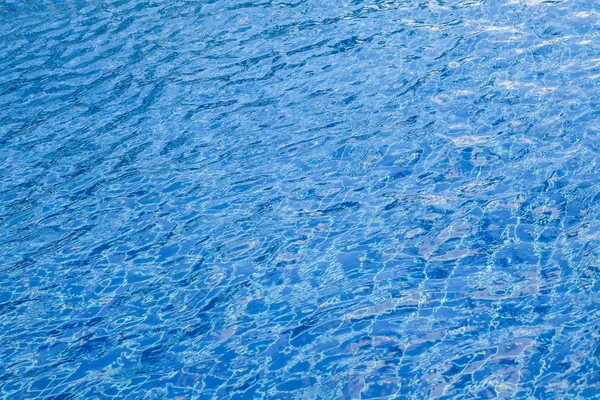 Desenfoque de la luz reflejándose en la piscina azul . — Foto de Stock