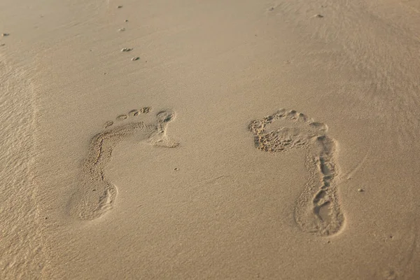 Ślady na plaża ze złotym piaskiem z bliska — Zdjęcie stockowe