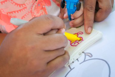 Baba ve çocuğun elleri kumaşa resim yapıyor..