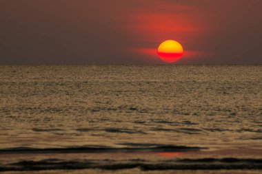 Büyük güneş denizin üzerinde batıyor güneşin kırmızı diski okyanustaki ufka dokunuyor..