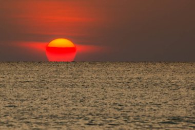 Büyük güneş denizin üzerinde batıyor güneşin kırmızı diski okyanustaki ufka dokunuyor..