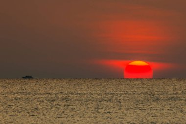Büyük güneş denizin üzerinde batıyor güneşin kırmızı diski okyanustaki ufka dokunuyor..