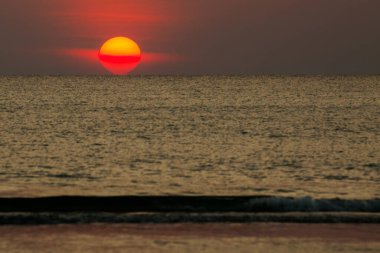 Büyük güneş denizin üzerinde batıyor güneşin kırmızı diski okyanustaki ufka dokunuyor..
