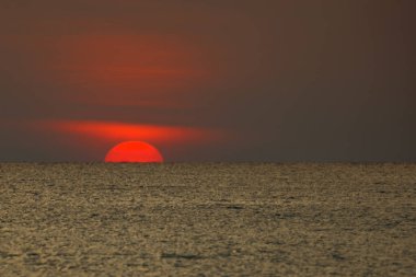 Büyük güneş denizin üzerinde batıyor güneşin kırmızı diski okyanustaki ufka dokunuyor..