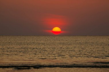 Büyük güneş denizin üzerinde batıyor güneşin kırmızı diski okyanustaki ufka dokunuyor..