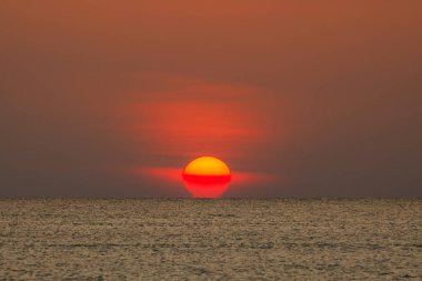 Büyük güneş denizin üzerinde batıyor güneşin kırmızı diski okyanustaki ufka dokunuyor..