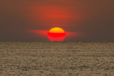 Büyük güneş denizin üzerinde batıyor güneşin kırmızı diski okyanustaki ufka dokunuyor..