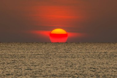 Büyük güneş denizin üzerinde batıyor güneşin kırmızı diski okyanustaki ufka dokunuyor..