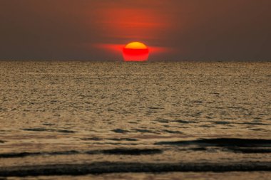Büyük güneş denizin üzerinde batıyor güneşin kırmızı diski okyanustaki ufka dokunuyor..