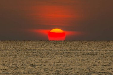 Büyük güneş denizin üzerinde batıyor güneşin kırmızı diski okyanustaki ufka dokunuyor..