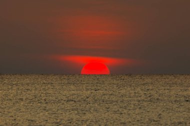 Büyük güneş denizin üzerinde batıyor güneşin kırmızı diski okyanustaki ufka dokunuyor..