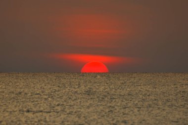 Büyük güneş denizin üzerinde batıyor güneşin kırmızı diski okyanustaki ufka dokunuyor..