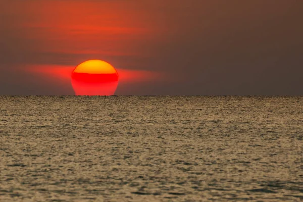 Büyük güneş denizin üzerinde batıyor güneşin kırmızı diski okyanustaki ufka dokunuyor..