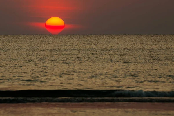 Büyük güneş denizin üzerinde batıyor güneşin kırmızı diski okyanustaki ufka dokunuyor..