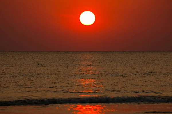 Büyük güneş denizin üzerinde batıyor güneşin kırmızı diski okyanustaki ufka dokunuyor..