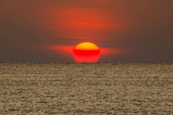 Büyük güneş denizin üzerinde batıyor güneşin kırmızı diski okyanustaki ufka dokunuyor..