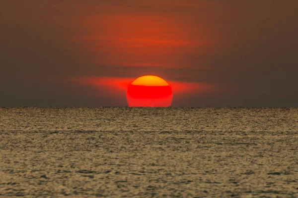 Büyük güneş denizin üzerinde batıyor güneşin kırmızı diski okyanustaki ufka dokunuyor..