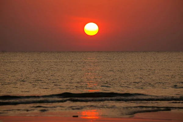 大太阳落在海面上 太阳的红盘触及海洋的地平线 图库图片