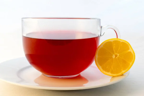 Glass cup of hot aromatic red tea with lemon — Stock Photo, Image