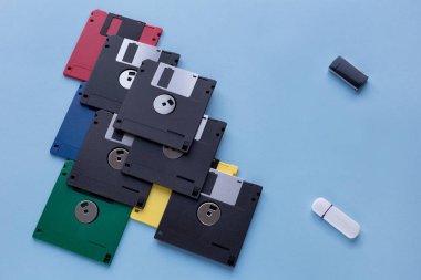 Dijital veri depolama cihazının evrimi. Disketler küçük flash sürücülere karşı. Mavi arka planda yalıtılmış.